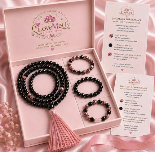 Caixa rosa aberta com japamala Superação, três pulseiras energéticas e cartão explicativo bilingue