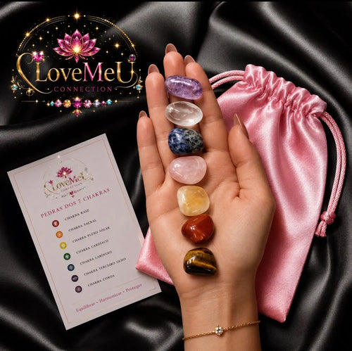 Mão a segurar as 7 pedras dos chakras, com saco de cetim rosa e cartão em português